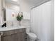 Bright bathroom featuring a white shower curtain, wood vanity and a large mirror at 1256 Xavier St, Denver, CO 80204