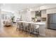 Open-concept kitchen featuring a quartz island with seating, stainless appliances, and bright living area at 1256 Xavier St, Denver, CO 80204