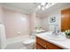 Bathroom featuring pink tile, a shower-tub combo, a toilet, a sink and a mirrored vanity at 10894 Depew Pl, Westminster, CO 80020