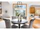Bright dining area features a wood table and four chairs beneath a modern light fixture with a window view at 10894 Depew Pl, Westminster, CO 80020