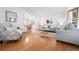 Inviting living room with bright white walls, hardwood flooring, and an open layout to the dining area at 10894 Depew Pl, Westminster, CO 80020
