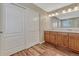 Bright bathroom features wood floors, double sink vanity with plenty of storage, and a large mirror at 2976 Open Sky Way, Castle Rock, CO 80109