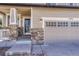 Close-up of a home's stone-accented front entry and garage, featuring a charming porch and well-maintained facade at 2976 Open Sky Way, Castle Rock, CO 80109