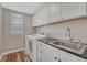 This laundry room features white cabinets, front loading washer and dryer, and a sink at 2976 Open Sky Way, Castle Rock, CO 80109