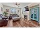 Comfortable living room featuring hardwood floors, a fireplace, and large windows for ample natural light at 2976 Open Sky Way, Castle Rock, CO 80109