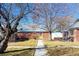 Charming brick home with a well-maintained front yard and mature trees at 1421 Jasmine St, Denver, CO 80220