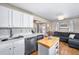 Bright kitchen featuring white cabinets, stainless steel appliances, and an island at 1421 Jasmine St, Denver, CO 80220