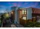 Charming brick townhome exterior with balconies, chimney and mature landscaping, set against a twilight sky at 2917 S Locust St, Denver, CO 80222