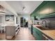 Bright kitchen features green cabinets, butcher block counters, and opens to a deck with views at 2917 S Locust St, Denver, CO 80222