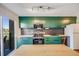 Modern kitchen with green cabinetry, stainless steel appliances, and a large island at 2917 S Locust St, Denver, CO 80222