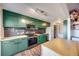 Modern kitchen features green cabinets, butcher block countertops, stainless steel appliances and stylish backsplash at 2917 S Locust St, Denver, CO 80222