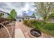 Large backyard featuring lawn, mature trees, gravel area, gardening space, and fire pit at 18472 E Atlantic Dr, Aurora, CO 80013