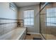 Featuring a shower and bath combination, with tan tiled walls and a natural lighting window at 18472 E Atlantic Dr, Aurora, CO 80013