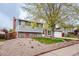 View of a two-story home with a combination of brick and gray siding, surrounded by rock landscaping at 18472 E Atlantic Dr, Aurora, CO 80013