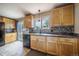 Beautiful kitchen features wood cabinets, black appliances, view to backyard, and updated backsplash at 18472 E Atlantic Dr, Aurora, CO 80013