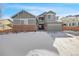 Two-story house with gray siding, brick accents, and a snow-covered front yard at 21436 E Mansfield Dr, Aurora, CO 80013