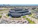 Aerial view of a stadium surrounded by parking lots, green spaces, and the city skyline in the distance at 2931 W 20Th Ave, Denver, CO 80211