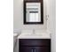 Stylish half bathroom with a dark vanity, quartz countertop, modern fixture, and square framed mirror at 2931 W 20Th Ave, Denver, CO 80211