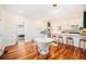 Open dining area with a white table, modern chairs, hardwood floors, and bar seating near the kitchen at 2931 W 20Th Ave, Denver, CO 80211