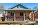 Charming brick home featuring a welcoming front porch with decorative planters and a metal railing at 2931 W 20Th Ave, Denver, CO 80211
