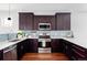 Modern kitchen featuring dark wood cabinetry, stainless steel appliances, and a stylish backsplash at 2931 W 20Th Ave, Denver, CO 80211