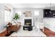 Cozy living room features a fireplace, a brown leather sofa, and two white armchairs at 2931 W 20Th Ave, Denver, CO 80211