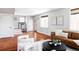 Bright living room featuring hardwood floors, a brown leather sofa, and modern artwork at 2931 W 20Th Ave, Denver, CO 80211