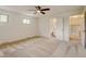 Spacious bedroom featuring a ceiling fan, neutral carpet, ensuite bathroom and natural light from two windows at 800 Mesa Ct, Broomfield, CO 80020