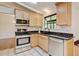 Cozy kitchen with stainless appliances, light wood cabinetry, granite counters, tile floor and view to the dining room at 800 Mesa Ct, Broomfield, CO 80020