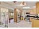 Bright kitchen featuring tile floors, stainless appliances, light wood cabinetry, a skylight, and an adjacent living area at 800 Mesa Ct, Broomfield, CO 80020