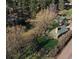 Charming log cabin with green roof nestled in a wooded area with a well-manicured lawn at 5502 Santa Clara Rd, Indian Hills, CO 80454