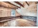 View of attic space featuring wooden walls, floors, and an exposed beam ceiling with a window at 5502 Santa Clara Rd, Indian Hills, CO 80454
