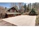 Charming log cabin with a driveway, surrounded by mature trees and foliage in a serene setting at 5502 Santa Clara Rd, Indian Hills, CO 80454