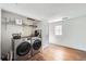 Bright laundry room with modern washer and dryer set, shelving, and natural light at 5502 Santa Clara Rd, Indian Hills, CO 80454