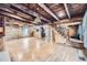 Spacious living room showcasing exposed wood beams, log walls, a wood stove and wooden staircase at 5502 Santa Clara Rd, Indian Hills, CO 80454