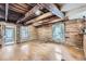 Charming living room featuring wood beam ceilings, log walls and natural light from the large windows at 5502 Santa Clara Rd, Indian Hills, CO 80454