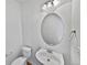 Clean bathroom with a vanity, toilet, and circular mirror at 9437 E 108Th Dr, Commerce City, CO 80640