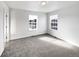 Bright bedroom with grey carpet and two large windows at 9437 E 108Th Dr, Commerce City, CO 80640