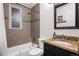 Bathroom featuring a shower-tub combo with neutral tile and granite countertops at 491 Campo St, Denver, CO 80221