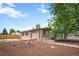 Single story home with a red front door, new landscaping, large shade tree and fenced yard in a quiet neighborhood at 491 Campo St, Denver, CO 80221