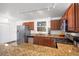 Updated kitchen features stainless steel appliances, granite countertops, wood cabinets and track lighting at 491 Campo St, Denver, CO 80221