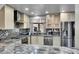 Updated kitchen featuring stainless steel appliances, modern backsplash, and plenty of counter space at 2518 S Ouray Way, Aurora, CO 80013