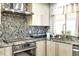 Close up of a modern kitchen with stainless steel appliances, granite countertops, and modern backsplash at 2518 S Ouray Way, Aurora, CO 80013