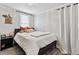 Cozy bedroom with a queen bed, neutral bedding, decorative pillows, and a side table with lamp at 1308 S Sherman St, Denver, CO 80210