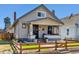 Charming home featuring a covered front porch, a quaint fence, and appealing curb appeal at 1308 S Sherman St, Denver, CO 80210