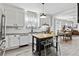 Bright kitchen with white cabinets, an island with seating, and stainless steel appliances adjacent to a dining area at 1308 S Sherman St, Denver, CO 80210