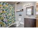 Bright bathroom features a toilet, vanity, mirror, and shower with a patterned curtain at 3100 Huron St # 2D, Denver, CO 80202