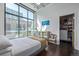 Bright bedroom with large windows, hardwood floors, ceiling fan, and a mirrored vanity at 3100 Huron St # 2D, Denver, CO 80202