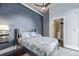 Bedroom boasts a ceiling fan, blue accent wall, and a closet with shelving at 3100 Huron St # 2D, Denver, CO 80202
