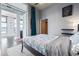 Bedroom with wood floors, a blue and white bedspread, and an open door to another room at 3100 Huron St # 2D, Denver, CO 80202